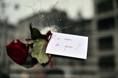 Una rosa con una nota en el agujero de bala en la ventana de un restaurante de la Rue de Charonne.