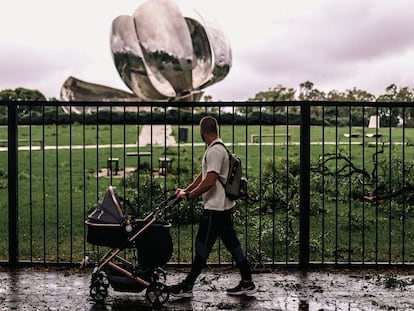 Un hombre con una carriola pasa frente a la escultura Floralis, dañada durante el temporal del fin de semana en Buenos Aires (Argentina).