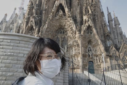La Sagrada Família mantiene sus puertas cerradas desde este viernes por riesgo de contagio del coronavirus. Esta turista oriental, protegida con mascarilla, se ha quedado sin entrar.