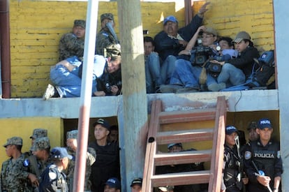Un grupo de periodistas se refugia de los enfrentamientos entre policías y familiares de los presos de la Granja Penal de Comayagua.