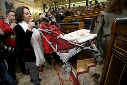 La diputada de Podemos, Carolina Bescansa, sube el carrito de su bebé a su escaño en el Congreso de los Diputados.
