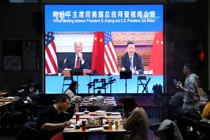 Le reunión entre los presidentes de China, Xi JInping, y EE. UU, Joe Biden, se muestra en la pantalla de un restaurante de Pekín este martes