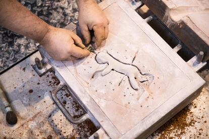 Un trabajador prepara el yeso donde se verterá el bronce líquido para crear la estatuilla.