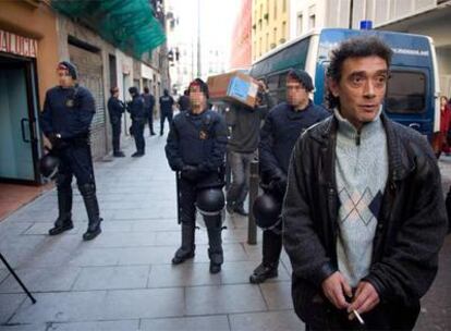 Manel González, rodeado de <i>mossos d&#39;Esquadra,</i> ayer después de ser desalojado de su piso en la calle de Robadors.