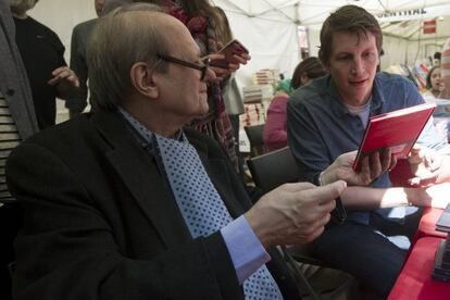 El escritor norteamericano Garth Risk Hallberg observa un libro de Pere Gimferrerdurante la tradicional fiesta de Sant Jordi.