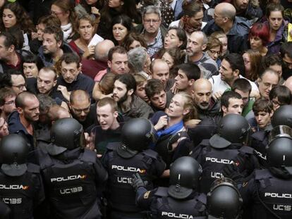 Agentes anti distúrbios da Polícia Nacional isolam catalães.