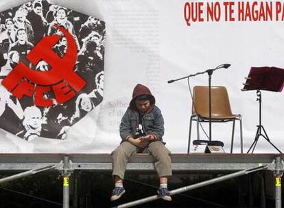 Un niño permanece sentado en el escenario de la Fiesta del PCE, en Vallecas.