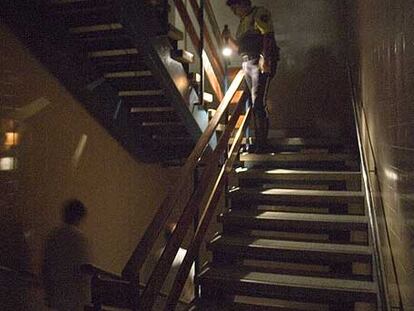 Un guardia urbano ilumina una escalera del hospital.