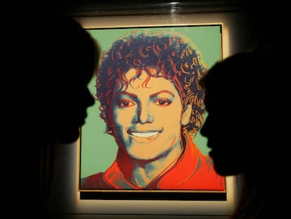 Dos visitantes frente al retrato de Michael Jackson hecho por Andy Warhol, expuesto en 2009 en en estadio O2 de Londres, donde Michael iba a dar una serie de conciertos antes de morir. 