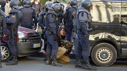 Unos policías custodian a un joven durante los incidentes entre estudiantes y policías en el centro de Valencia por las protestas tras las detenciones a las puertas del Instituto Lluis Vives.