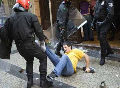 Un policía vasco forcejea con un manifestante en la manifestación de ayer en San Sebastián.