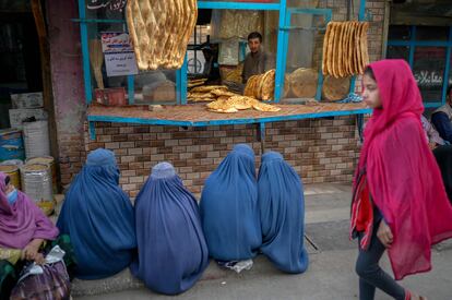 Cuatro mujeres con burka esperan pan gratis en una panadería de Kabul, el jueves.