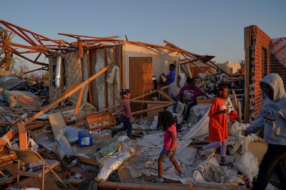 Shirley Stamps, 58, is surrounded by her grandchildren as she sits on her bed and sorts through her belongings in the wreckage of her home after thunderstorms spawning high straight-line winds and tornadoes ripped across the state in Rolling Fork, Mississippi, U.S., March 25, 2023.