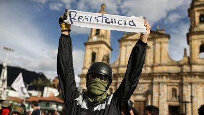 Un manifestante sostiene una pancarta que reza 