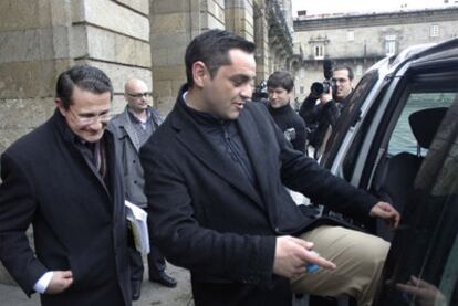 Espadas entra en un taxi seguido del líder del PP en Santiago, Conde Roa, tras hacerse pública la dimisión del primero.