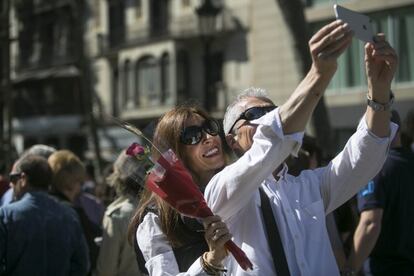 Una parella es fa una fotografia a la Rambla per Sant Jordi.