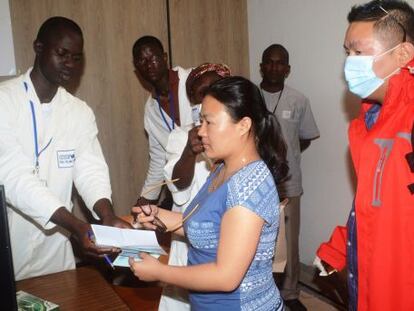 Empleados del puesto de control sanitario en el aeropuerto de Conakry (Guinea) realizan pruebas a pasajeros antes de que salgan del pa&iacute;s.