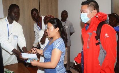 Empleados del puesto de control sanitario en el aeropuerto de Conakry (Guinea) realizan pruebas a pasajeros antes de que salgan del país.