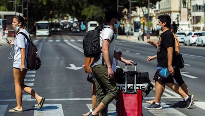 Varios turistas con maletas caminan por el centro de Málaga.