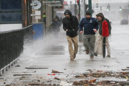 Varias personas caminan durante el temporal cerca de la bahía de Boston, en el Estado de Massachusetts.
