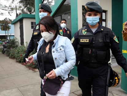 La policía escolta a una de las mujeres detenidas en la fiesta en la que 13 personas fallecieron en una estampida en Lima.