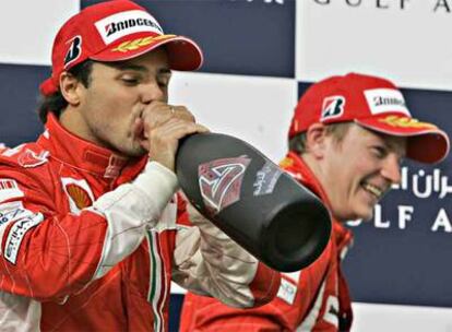 Felipe Massa, el ganador, bebe en el podio junto a Kimi Raikkonen, su compañero en Ferrari, segundo.