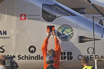 El piloto, Bertrand Piccard (interior avión) es saludado a través de una escotilla por su compañero Andre Borschberg, antes de desembarcar del avión.