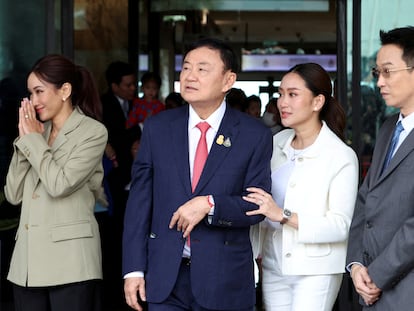 El ex primer ministro Thaksin Shinawatra camina junto a sus tres hijos en el aeropuerto de Bangkok, este martes 22 de agosto antes de ser encarcelado.