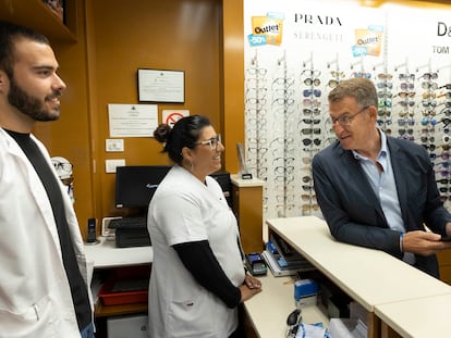 El presidente del Partido Popular, Alberto Núñez Feijóo, conversa con la empleada de una óptica en La Laguna (Tenerife) este lunes.