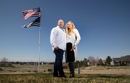 Jennifer and Tim Kohl poses for a photo in their front yard with the American flag and a thin blue line flag in Star, Idaho, on April 14, 2023.