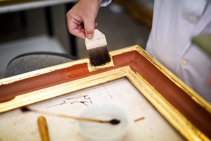 Aplicación del pan de oro a un marco para dorar en el Taller de restauración de dorado y estucos de Patrimonio Nacional, en el Palacio Real de Madrid, el 29 de mayo.