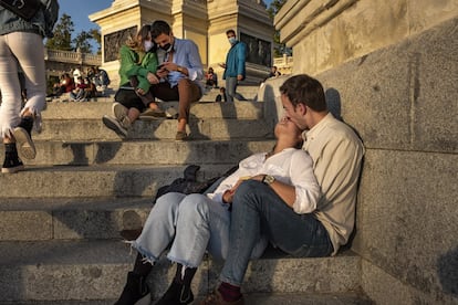 Con las restricciones, los parques toman más protagonismo para disfrutar del tiempo libre. Una pareja toma el sol otoñal en el Retiro.