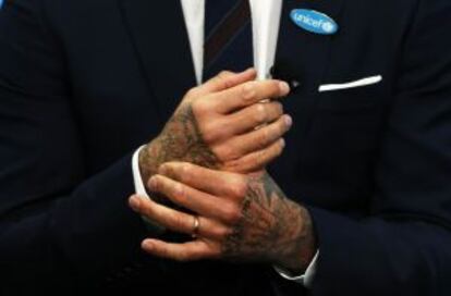 El exfutbolista David Beckham se frota sus manos tatuadas durante el acto de Unicef en Londres.