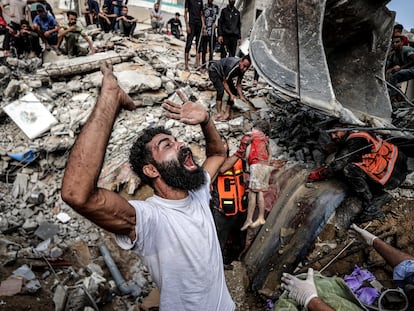 Un hombre palestino llora durante la búsqueda de heridos entre los escombros de un edificio derruido, a causa de un ataque israelí, este martes en el campo de refugiados de Shati, en Gaza.