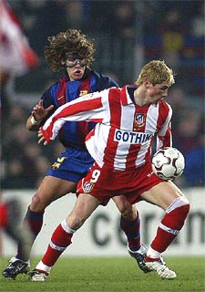 Fernando Torres intenta controlar el balón ante Puyol.