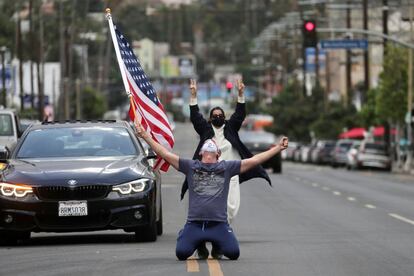 Christopher Paulsen sostiene un abandera mientras celebra la victoria demócrata en la calzada del bulevar Sunset en Los Ángeles, California.