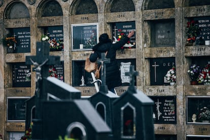 Una mujer acaricia un nicho en el cementerio de Boisaca, en Santiago de Compostela, este miércoles.