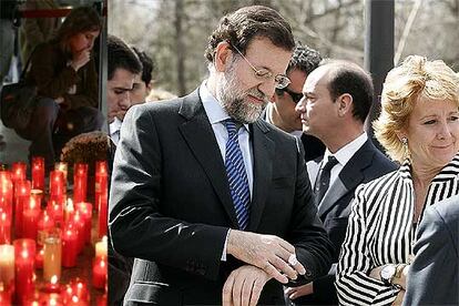 A la izquierda, velas en recuerdo de los atentados en la estación de Atocha. A la derecha, Rajoy y Aguirre, en el acto organizado por la AVT.