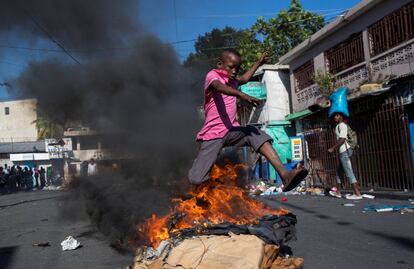 Un niño salta una barricada en llamas cerca del mercado de Petionville, durante una jornada de protestas en Puerto Príncipe (Haití). 