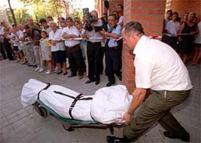 Personal de servicio funerario trasladan el cadáver de una de las fallecidas.