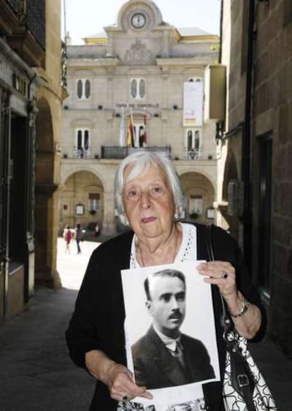 Lolita Suárez Breta, sostiene un retrato de su padre, Manuel Suárez Castro, frente al Ayuntamiento de Ourense.
