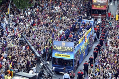 El autobús con los jugadores del Barça, rodeado de seguidores, durante el recorrido hasta el Camp Nou.