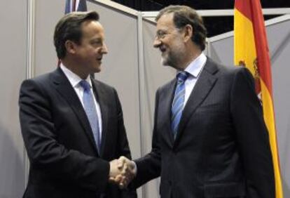 Rajoy (derecha), saluda a Cameron, antes del encuentro que han mantenido hoy en Chicago.