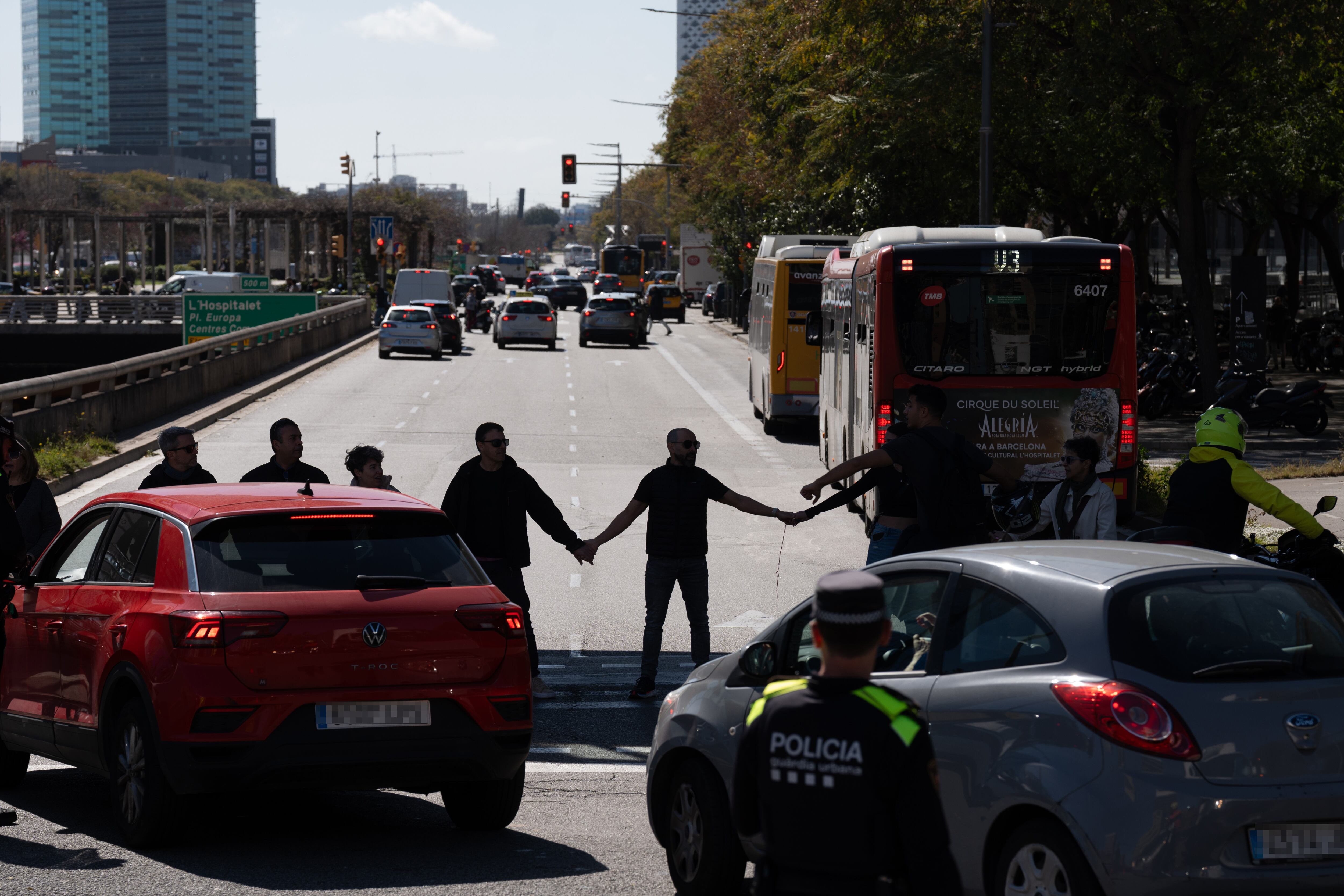 Manifestantes hacen una cadena humana durante concentración convocada por sindicatos en el corte de la Plaça Cerdà (Barcelona).