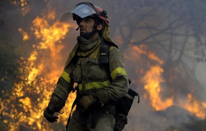 Un bombero camina entre el bosque ardiendo en las cercanías de la localidad de Santotirso el lunes 17 de octubre.