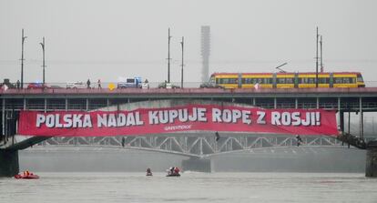 Pancarta de activistas de Greenpeace en la que se podía leer "Polonia aún compra petróleo a Rusia", en un puente sobre el río Vístula, en Varsovia, este viernes, 24 de febrero.