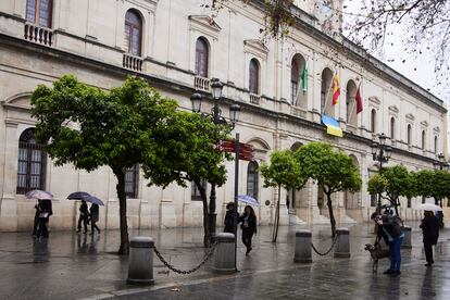 Varias personas caminan frente a la sede del ayuntamiento de Sevilla