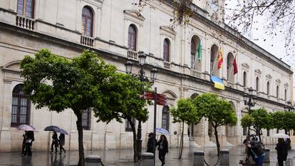 Varias personas caminan frente a la sede del ayuntamiento de Sevilla