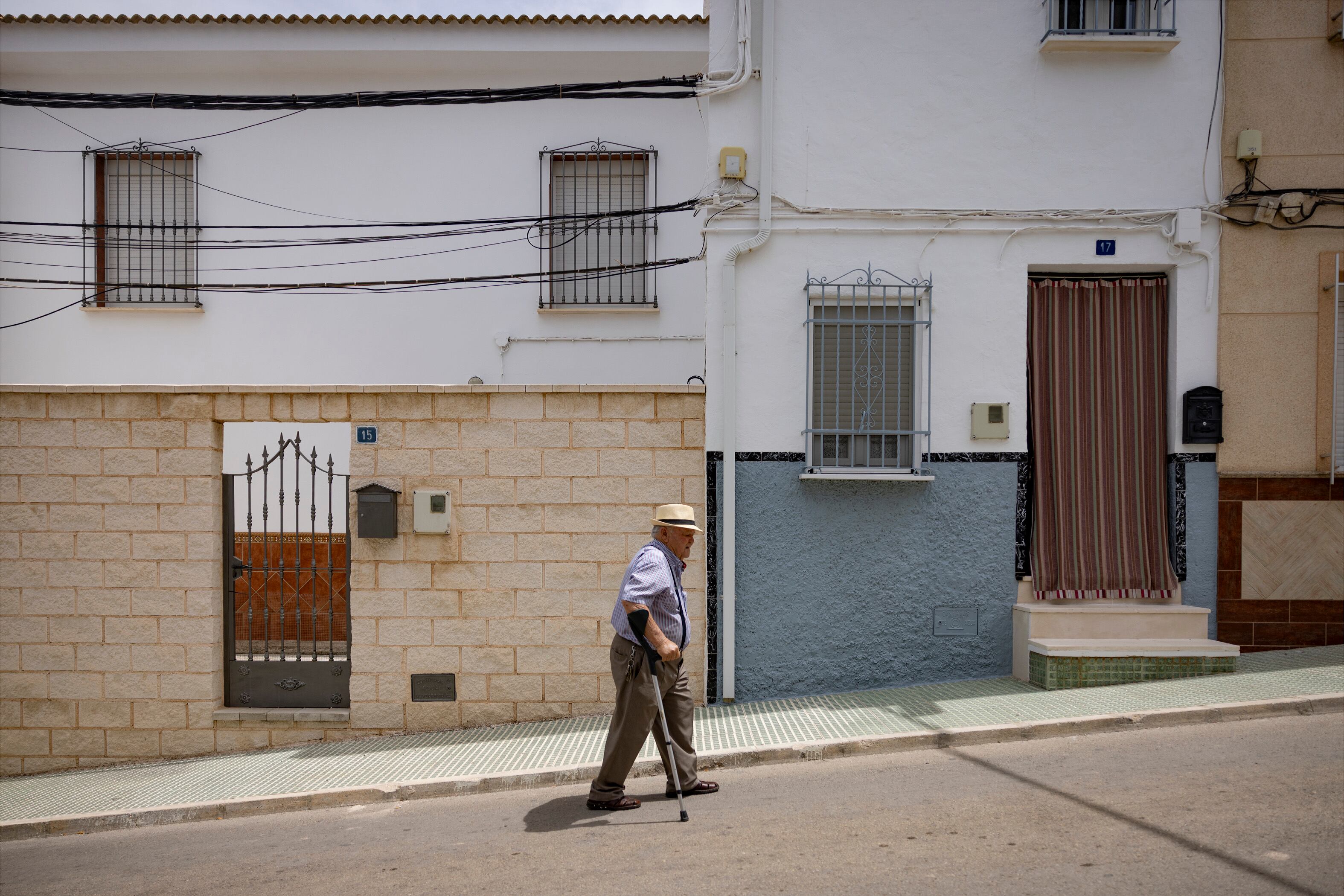 Un vecino pasa frente a la casa de la familia política de Santos Cerdán, en el número 17 de la calle Tebas, en Los Corrales (Sevilla), este jueves.