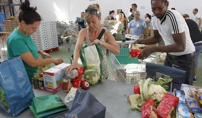 Social workers handing out food at a Cáritas center in Valencia.